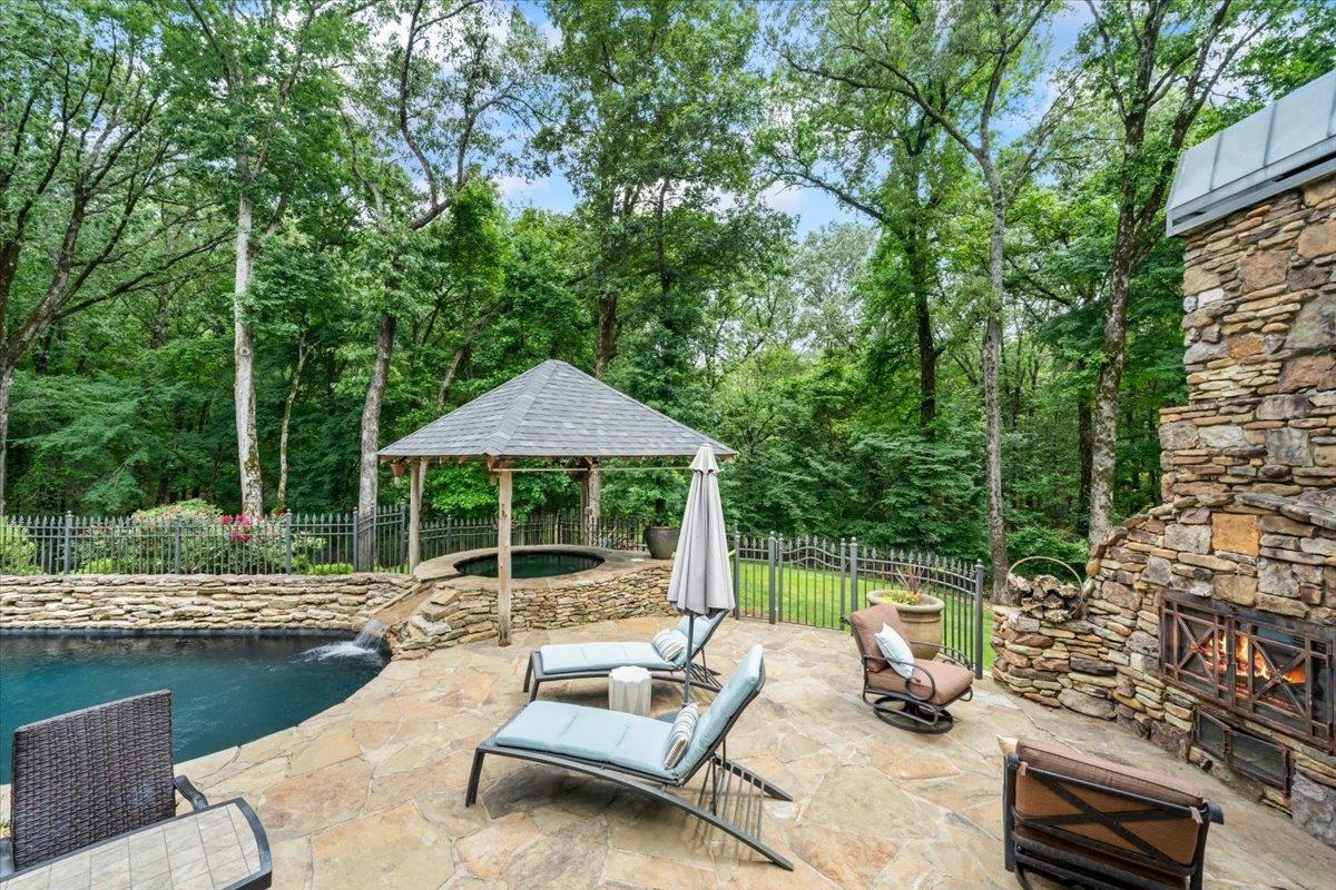10951 Raleigh Lagrange Road East Eads, TN 38028 - Photo 22 of 40 a view of a patio with couches table and chairs under an umbrella with large trees