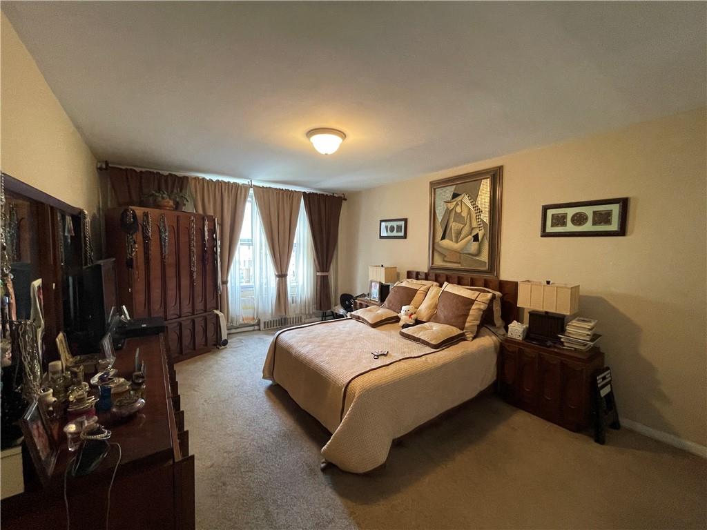 1200 Gravesend Neck Road, Unit 3B Brooklyn, NY 11229 - Photo 12 of 13 a bedroom with a bed mirror and window