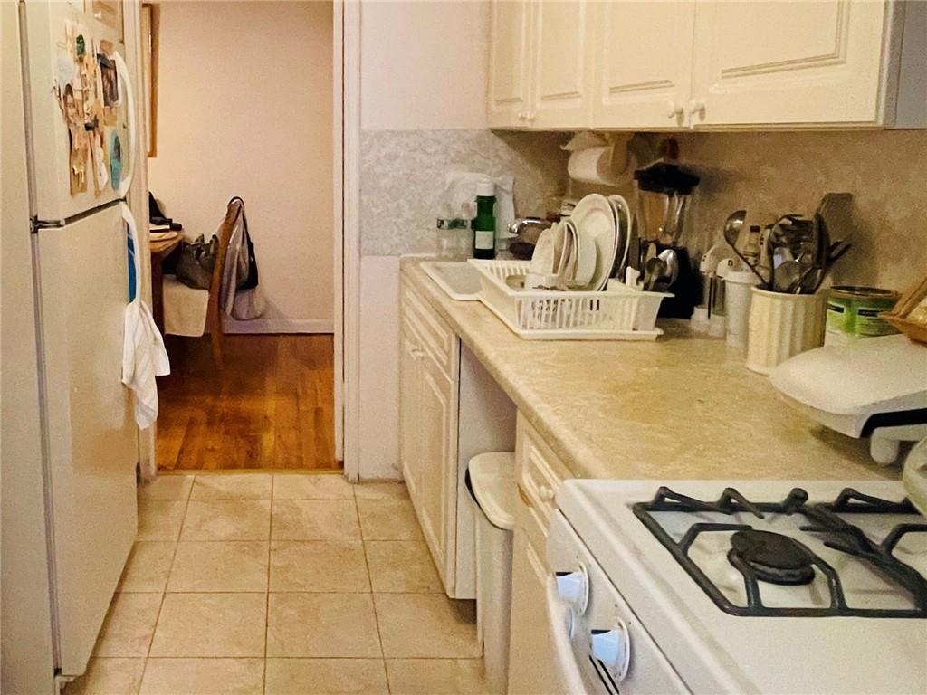 1200 Gravesend Neck Road, Unit 3B Brooklyn, NY 11229 - Photo 8 of 13 a kitchen with a sink a stove and storage racks