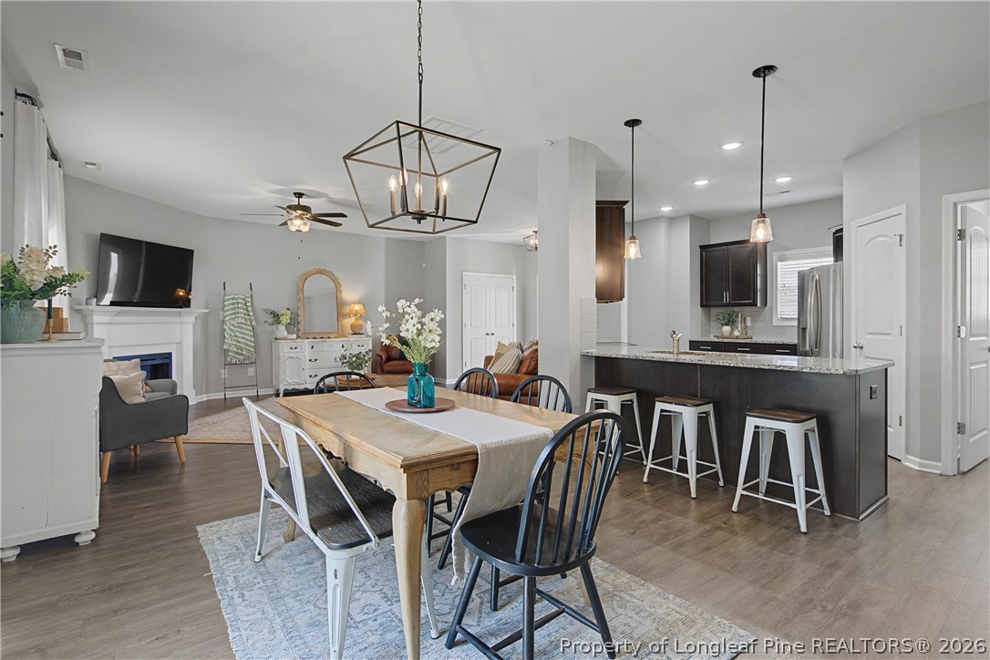 143 Ledgebrook Lane Raeford, NC 28376 - Photo 15 of 50 a view of a dining room with furniture a chandelier and wooden floor