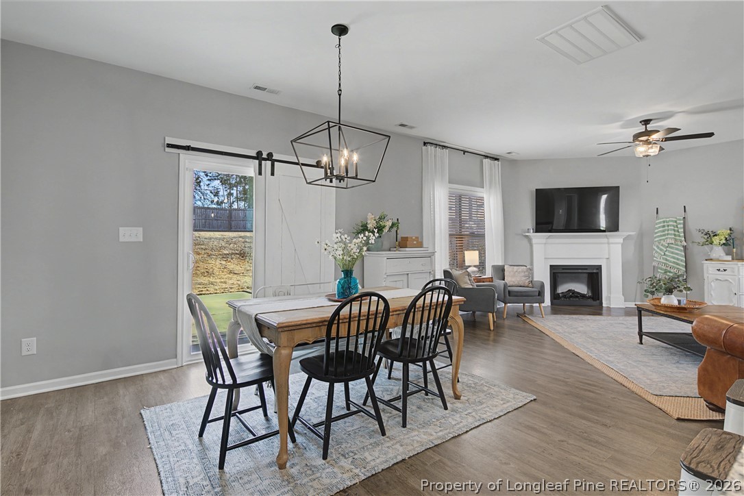 143 Ledgebrook Lane Raeford, NC 28376 - Photo 16 of 50 a view of a dining room with furniture a chandelier and wooden floor