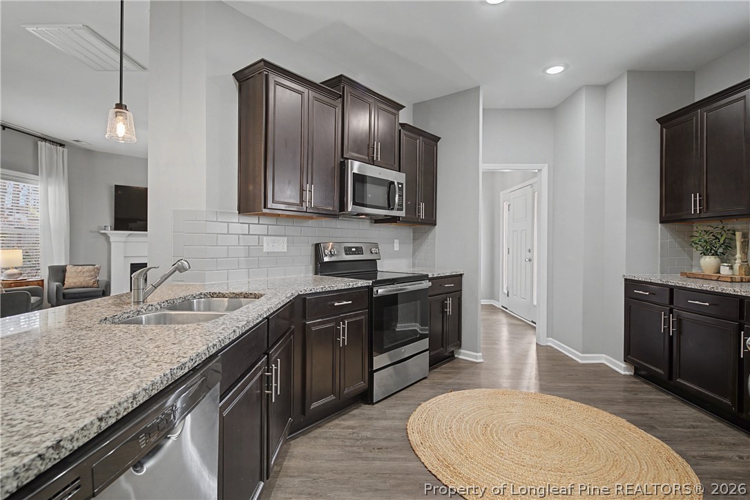 143 Ledgebrook Lane Raeford, NC 28376 - Photo 18 of 50 a kitchen with stainless steel appliances granite countertop a sink stove microwave and refrigerator