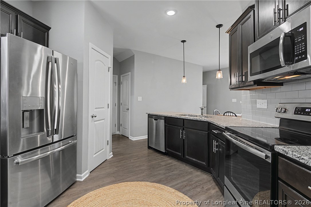 143 Ledgebrook Lane Raeford, NC 28376 - Photo 22 of 50 a kitchen with stainless steel appliances granite countertop a refrigerator a stove and a sink