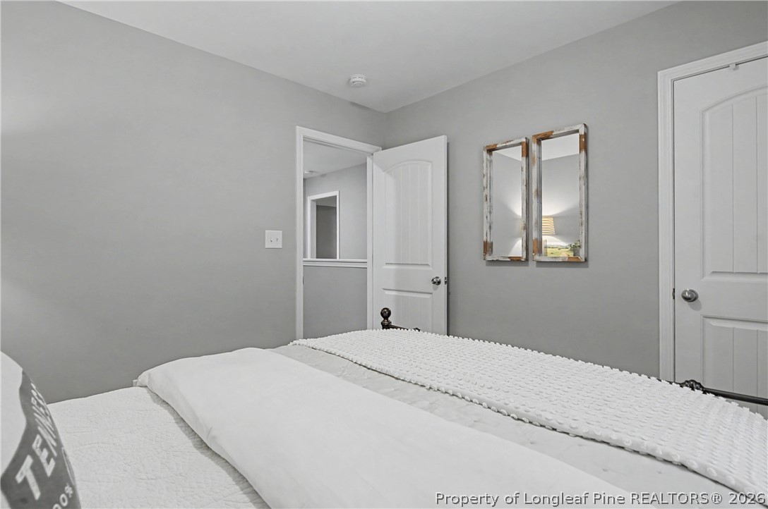 143 Ledgebrook Lane Raeford, NC 28376 - Photo 36 of 50 a bedroom with a white bed and a chandelier