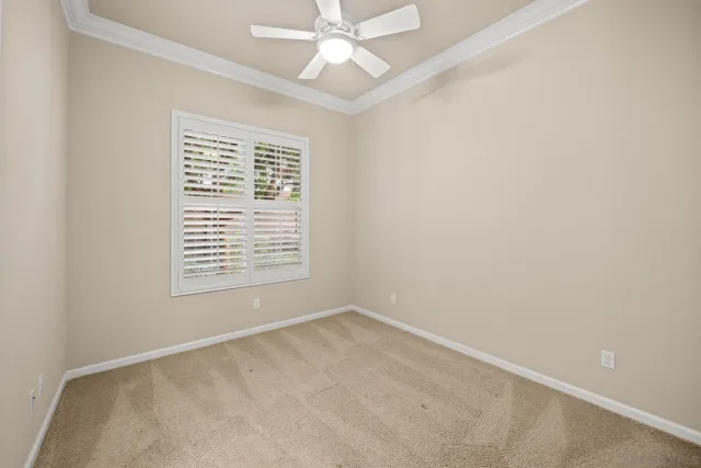 an empty room with a window and a fan