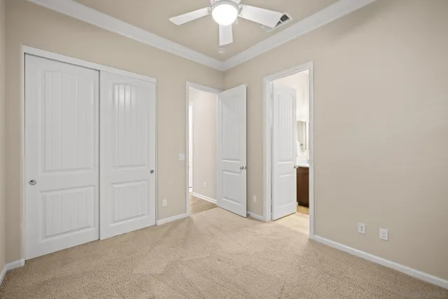 a view of an empty room and chandelier fan