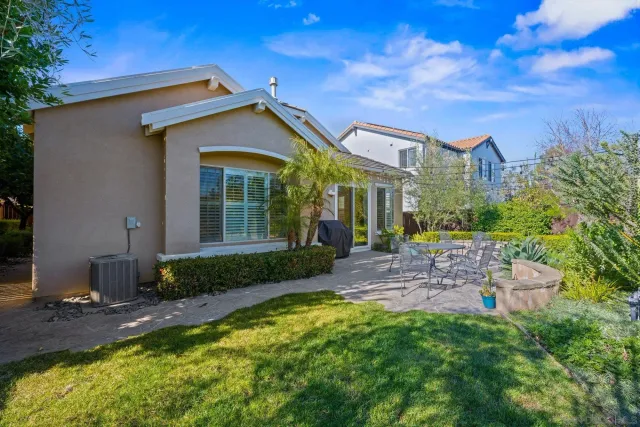 a view of a house with backyard and sitting area