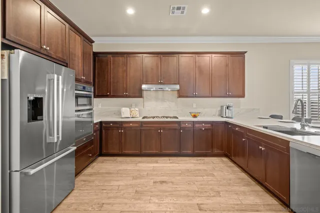 a kitchen with stainless steel appliances granite countertop a refrigerator and a sink