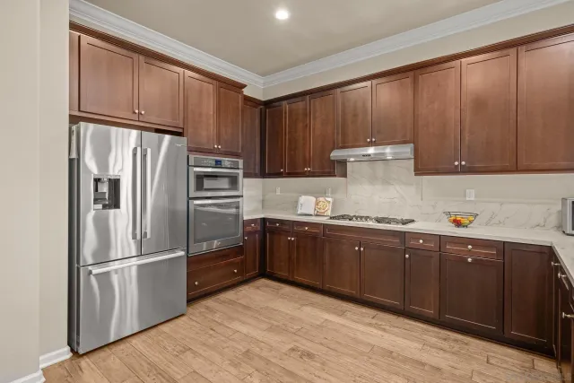 a kitchen with granite countertop wooden cabinets and stainless steel appliances