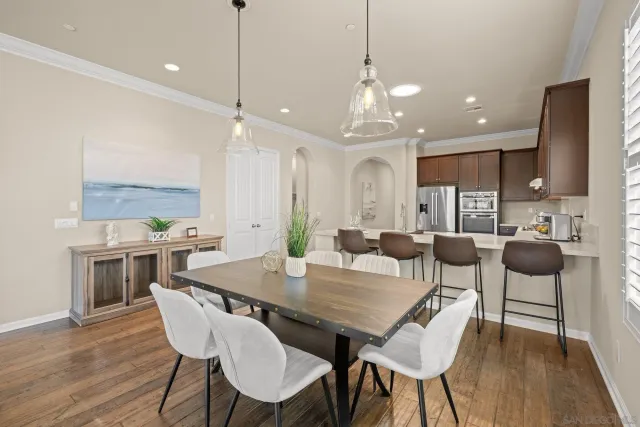 a view of a dining room with furniture a rug and wooden floor