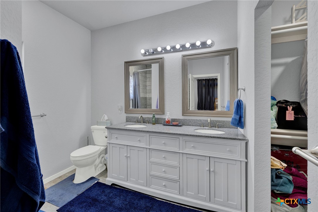 305 Lake Crest Spring Branch, TX 78070 - Photo 12 of 38 a bathroom with a double vanity sink and a toilet