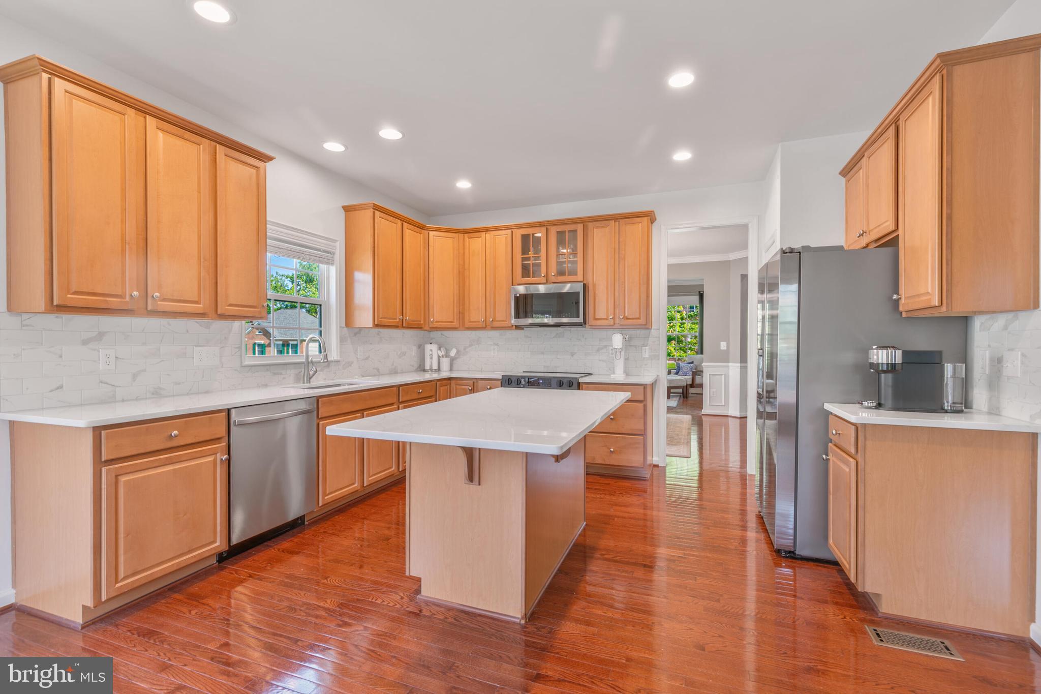 40652 Banshee Drive Leesburg, VA 20175 - Photo 17 of 51 a kitchen with stainless steel appliances granite countertop wooden cabinets a sink and dishwasher a refrigerator with wooden floor