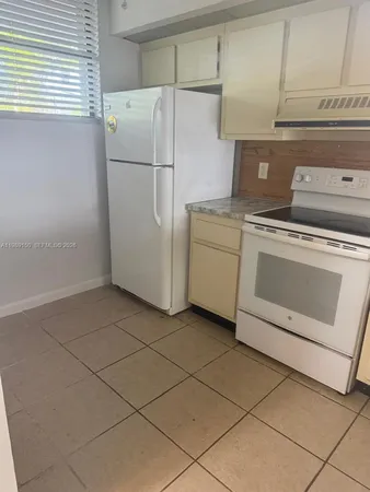 a white refrigerator freezer and a stove sitting inside of a kitchen
