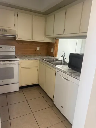 a kitchen with a stove a sink and a refrigerator