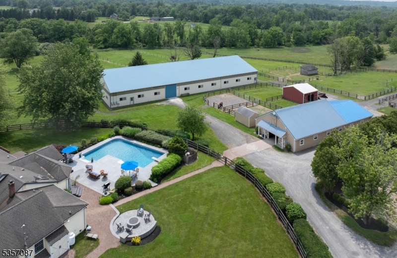 an aerial view of a house with garden space lake view and a car parked on the road