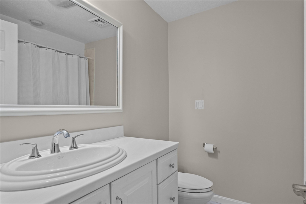 37 Constitution Lane, Unit 12 Danvers, MA 01923 - Photo 22 of 38 a bathroom with a granite countertop sink a toilet and a mirror