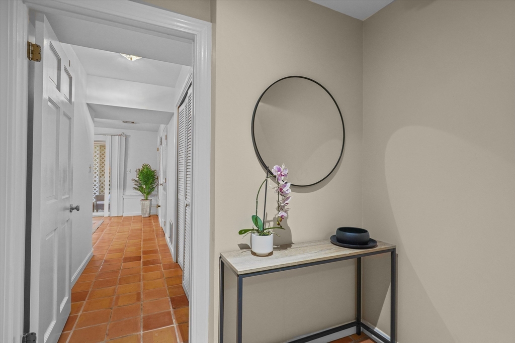 37 Constitution Lane, Unit 12 Danvers, MA 01923 - Photo 30 of 38 a view of a hallway with wooden floor and a potted plant