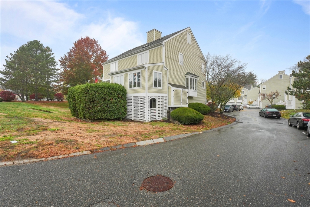37 Constitution Lane, Unit 12 Danvers, MA 01923 - Photo 35 of 38 a view of a white house with a yard and large trees
