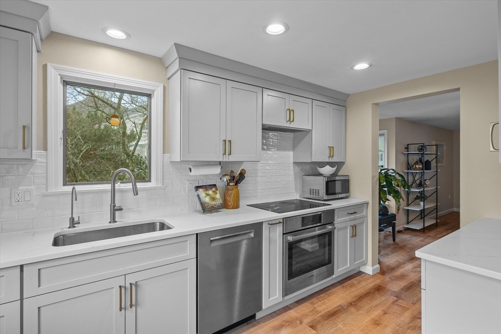 37 Constitution Lane, Unit 12 Danvers, MA 01923 - Photo 4 of 38 a kitchen with a sink stove and cabinets