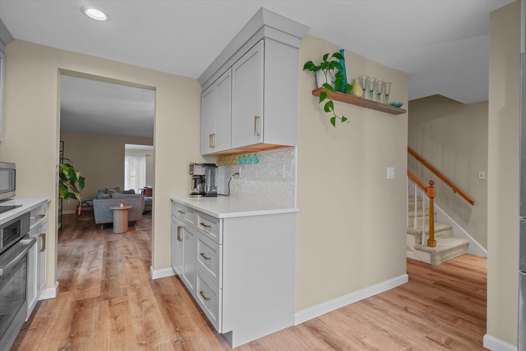 37 Constitution Lane, Unit 12 Danvers, MA 01923 - Photo 8 of 38 a kitchen with kitchen island wooden floor center island and stainless steel appliances