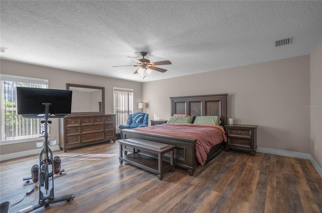5466 West Tortuga Loop Lecanto, FL 34461 - Photo 18 of 41 a spacious bedroom with a bed and wooden floor