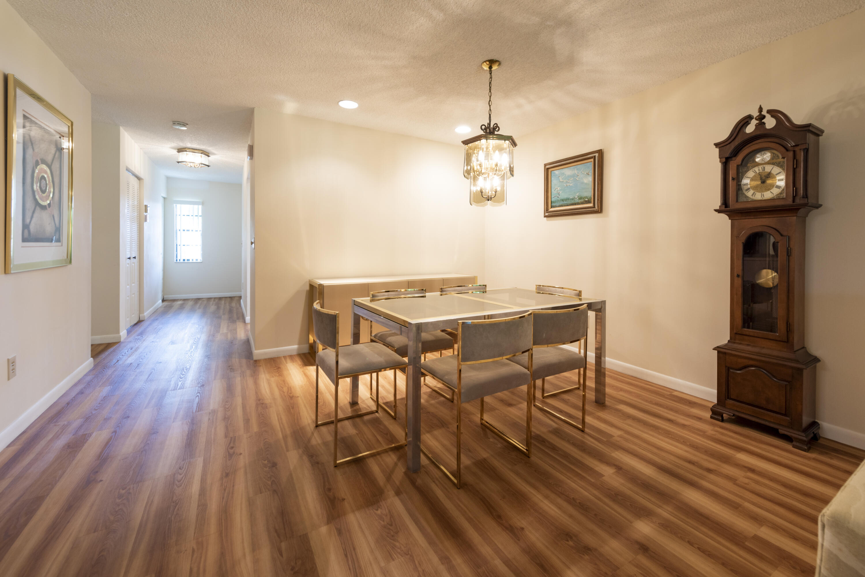 9199 Pecky Cypress Lane, Unit 7F Boca Raton, FL 33428 - Photo 12 of 20 a view of a dining room with furniture wooden floor and chandelier