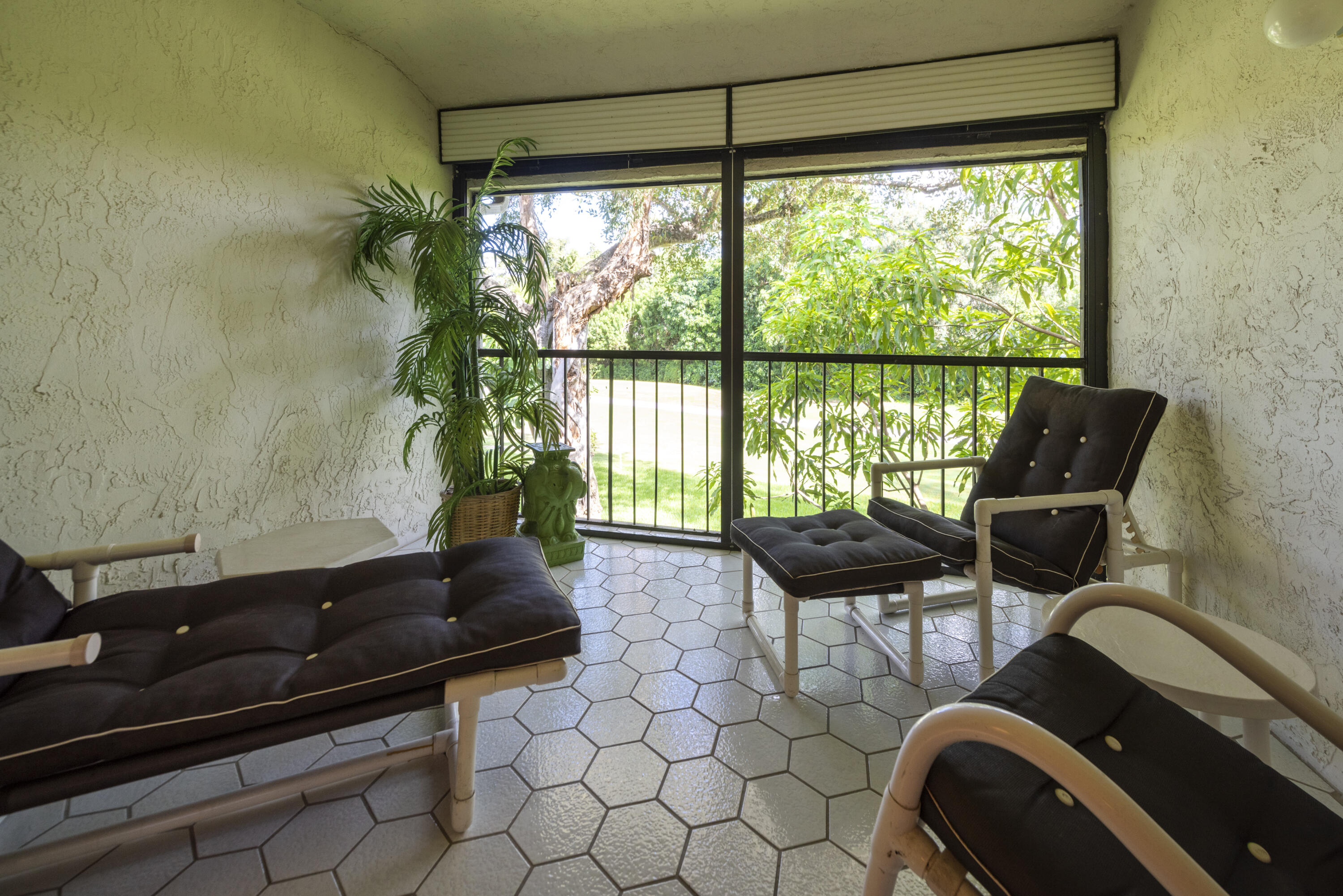9199 Pecky Cypress Lane, Unit 7F Boca Raton, FL 33428 - Photo 16 of 20 a living room with furniture and a floor to ceiling window