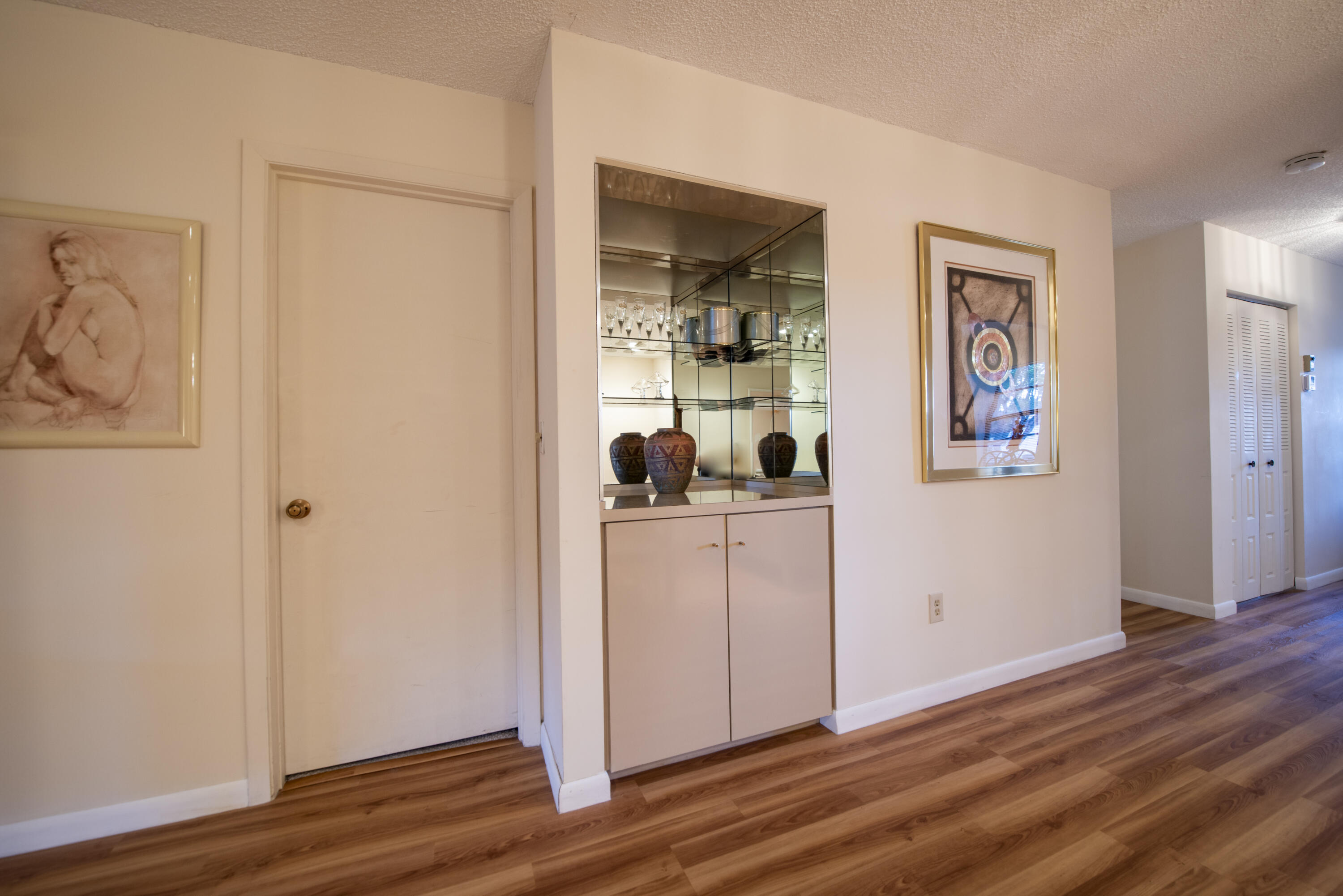 9199 Pecky Cypress Lane, Unit 7F Boca Raton, FL 33428 - Photo 18 of 20 a view of a hallway with wooden floor and closet