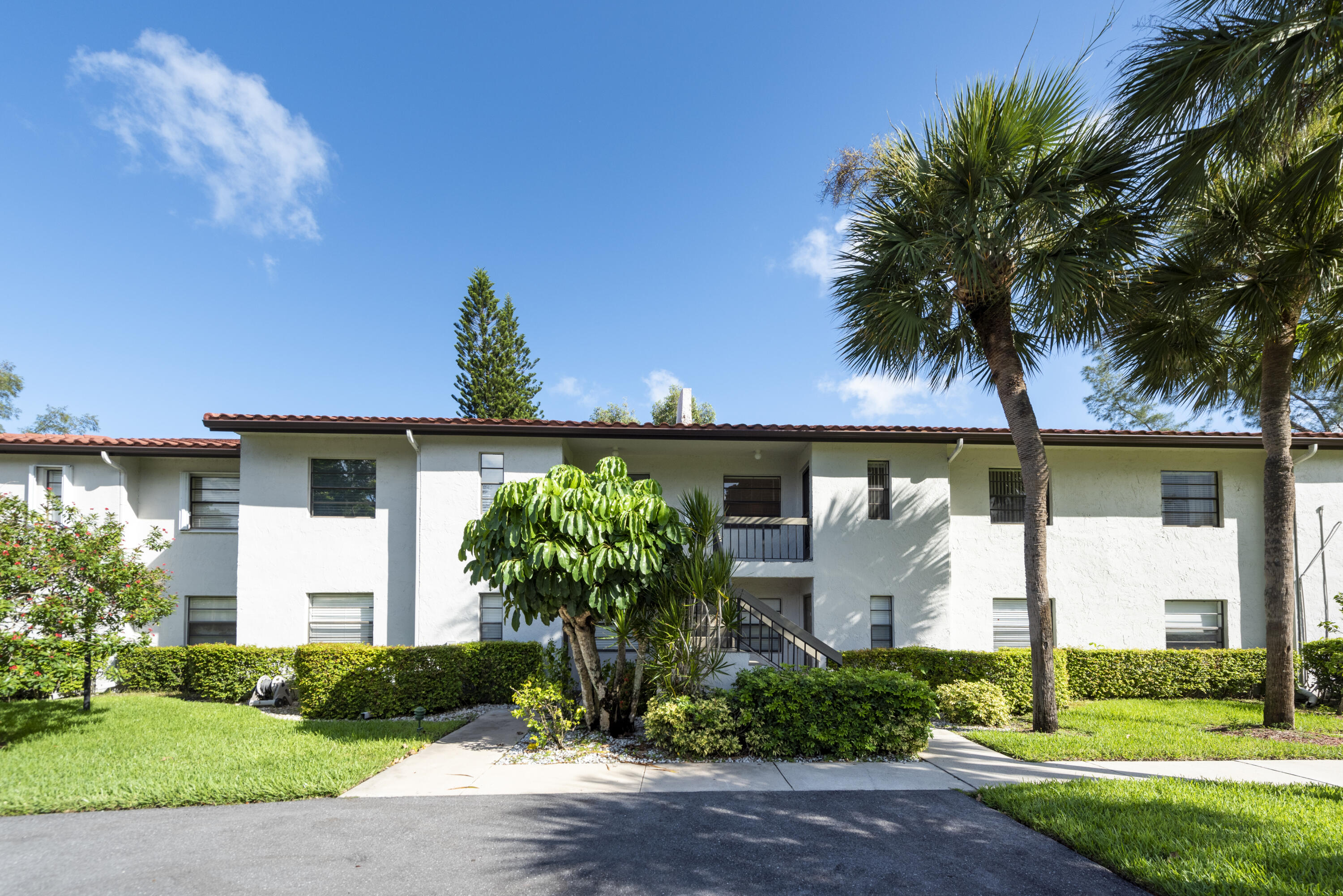 9199 Pecky Cypress Lane, Unit 7F Boca Raton, FL 33428 - Photo 2 of 20 a front view of a house with garden