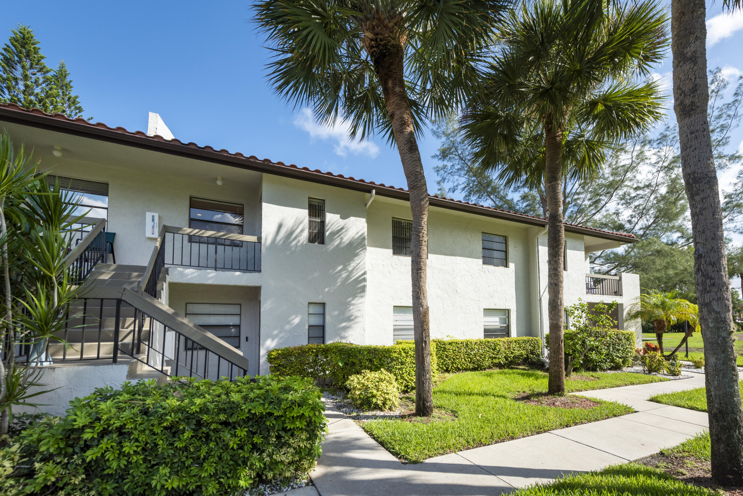 9199 Pecky Cypress Lane, Unit 7F Boca Raton, FL 33428 - Photo 3 of 20 a front view of a house with garden