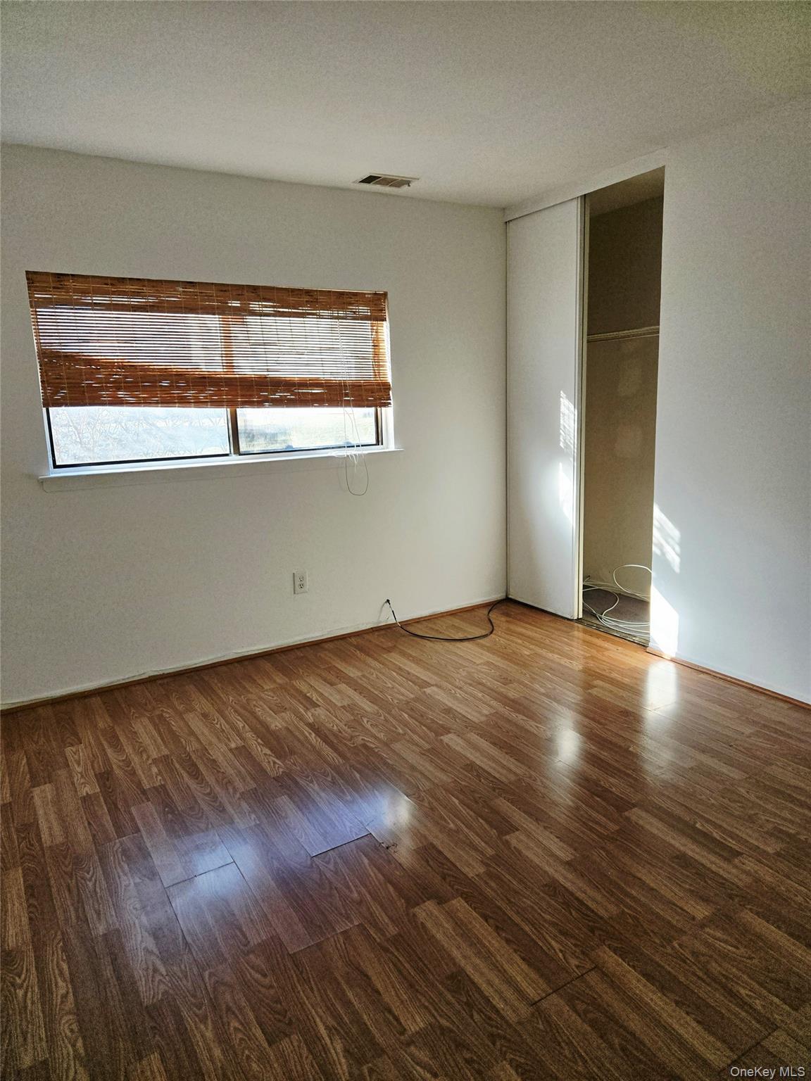79 Pointe Circle South, Unit 79 Coram, NY 11727 - Photo 21 of 39 Unfurnished bedroom with wood finished floors and a closet