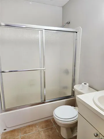 a white toilet sitting next to a shower