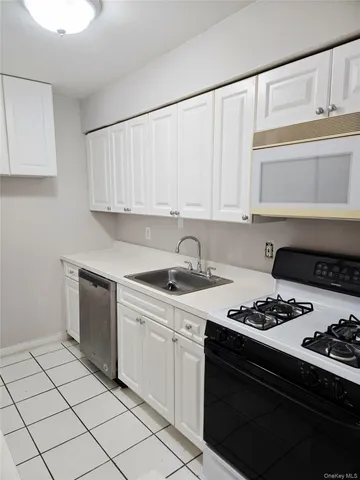 a kitchen with a sink stove top oven and cabinets