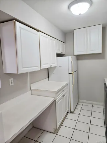 a kitchen with white cabinets and white appliances