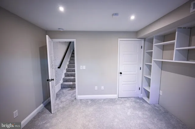 a view of room with stairs and a hallway