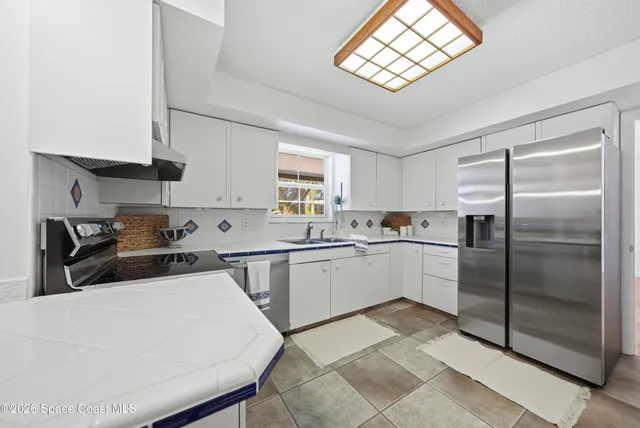 a kitchen with a refrigerator a sink and cabinets