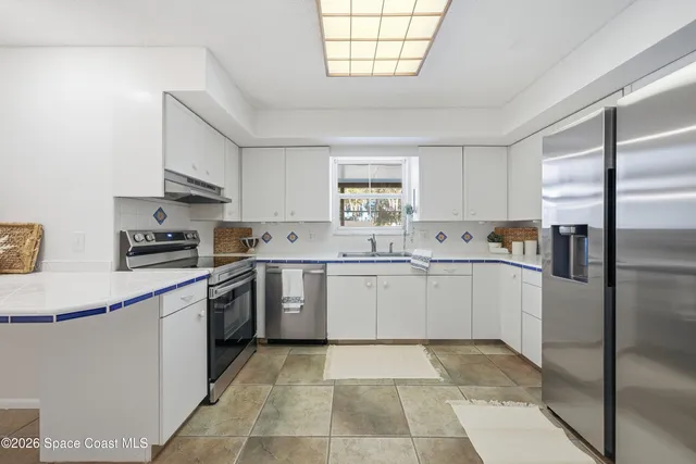a kitchen with stainless steel appliances granite countertop a stove a sink and a refrigerator