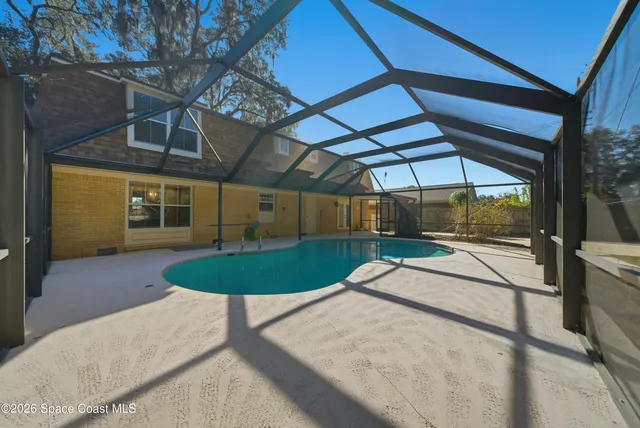 an aerial view of residential houses with outdoor space and trees