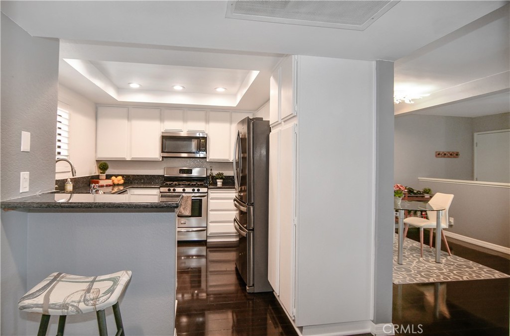 16551 Grunion Lane, Unit 204 Huntington Beach, CA 92649 - Photo 13 of 45 a kitchen with kitchen island a counter space a sink appliances and cabinets