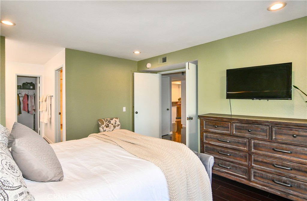 16551 Grunion Lane, Unit 204 Huntington Beach, CA 92649 - Photo 28 of 45 a bedroom with a bed and a flat screen tv in the kitchen