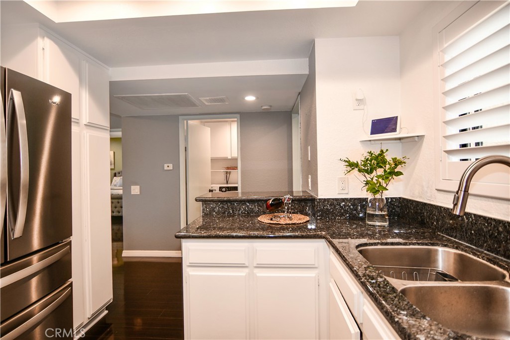 16551 Grunion Lane, Unit 204 Huntington Beach, CA 92649 - Photo 10 of 45 a kitchen with granite countertop a refrigerator and a sink