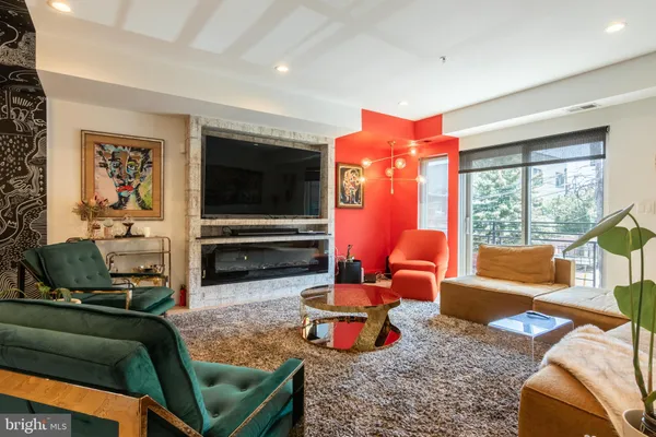 a living room with furniture flat screen tv and a large window