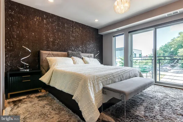 a bedroom with a bed and a large window