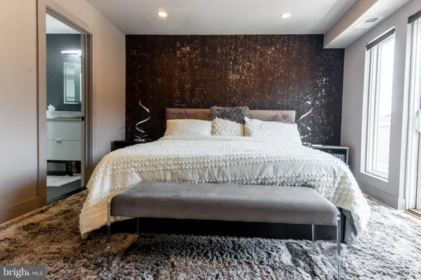 a bedroom with a bed and a large window