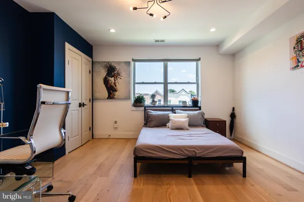 a bedroom with a bed and wooden floor