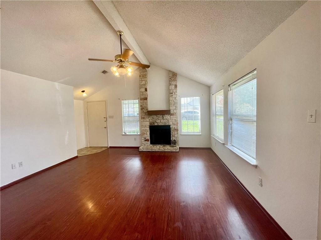 16927 Whitebrush Loop Austin, TX 78717 - Photo 2 of 28 an empty room with wooden floor fireplace and windows