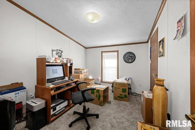 a view of a workspace with furniture and a window