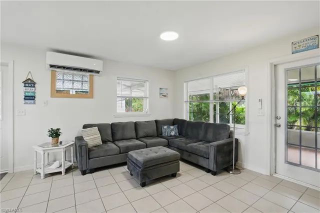 a living room with furniture a flat screen tv and a large window