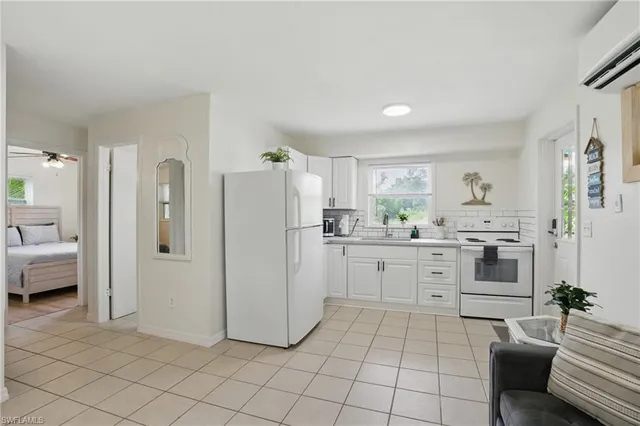 a kitchen with white cabinets and white appliances