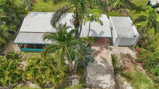a view of a house with a yard and palm trees
